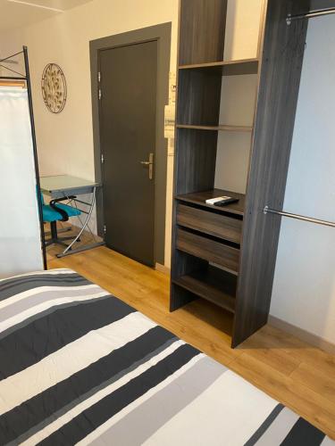 a bedroom with a bed and a dresser and a desk at Nancy, Magnifique studio totalement climatisé, meublé, salle de bains et wc séparés, parking privé, cuisine équipée, WIFI in Malzéville