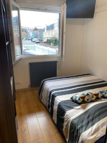 a bedroom with a bed with a large window at Nancy, Magnifique studio totalement climatisé, meublé, salle de bains et wc séparés, parking privé, cuisine équipée, WIFI in Malzéville