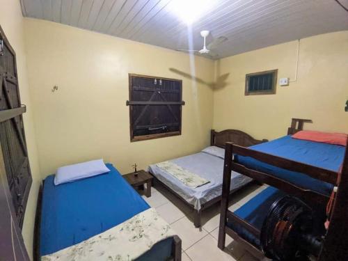 a room with two beds and a window at Algodoal Casa Verde in Maracanã
