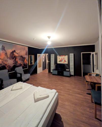a bedroom with a large bed and a living room at Puschkin Rooms in Berlin