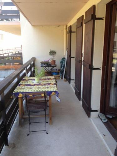 une table et des chaises sur le balcon d'un bâtiment dans l'établissement Grand T2 centre Villard-de-Lans, à Villard-de-Lans