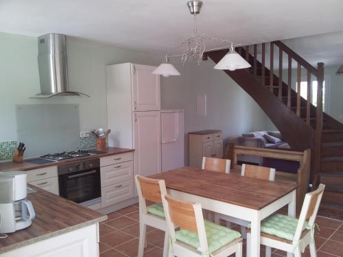 une cuisine avec une table à manger et un escalier dans l'établissement Fossat, à Villautou