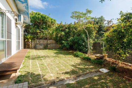 a garden in the backyard of a house at オーシャンビューの絶景UnclesHouse海の宿は美ら海水族館近く1棟貸 in Motobu