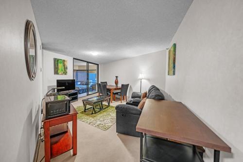 a living room with a couch and a table at Chic DT Honolulu Executive Condo condo in Honolulu