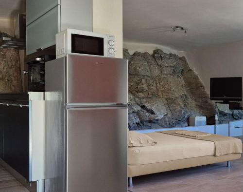 a kitchen with a refrigerator with a microwave on top at Villas On The Rock Afissos in Afissos