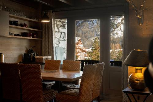 une salle à manger avec une table et des chaises et une fenêtre dans l'établissement Résidence VAL VILLAGE, skis aux pieds, Duplex 3 chambres 75 m2 - by MONTBLANC LODGE, à Val dʼIsère
