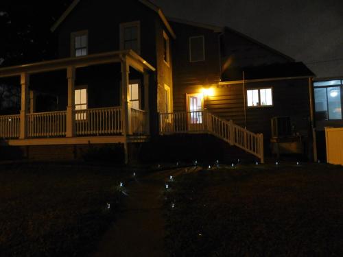 a house with a porch at night with a light at The Blue Victorian Waterview Home in Hampton