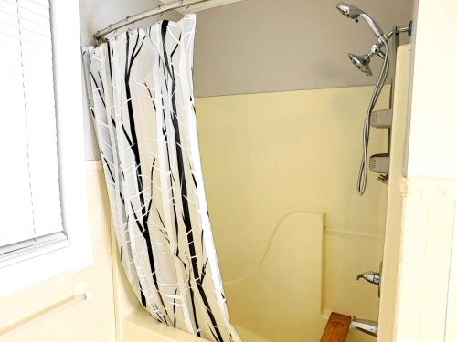 a shower curtain in a bathroom next to a window at The Blue Victorian Waterview Home in Hampton