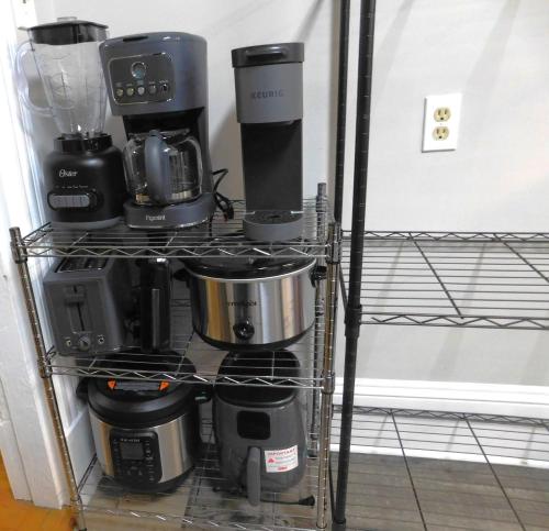 a shelf full of coffee pots and pans at The Blue Victorian Waterview Home in Hampton