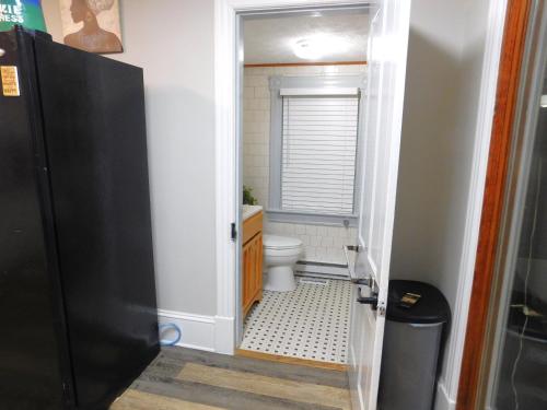 a small bathroom with a toilet and a window at The Blue Victorian Waterview Home in Hampton