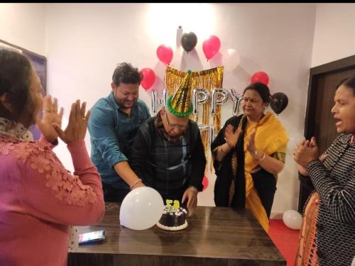 a group of people standing around a table with a birthday cake at Entire apartment khajuraho in Khajurāho