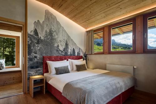 a bedroom with a bed in a room with windows at Chalet La Varieté in La Villa
