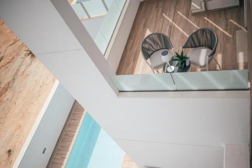 Laguna Beach Villa Veintidos في توريفايجا: غرفة بها كرسيان على رف في السقف