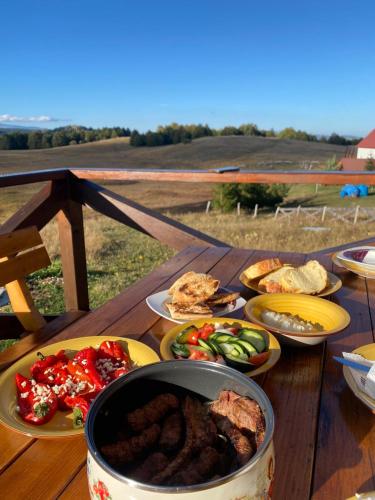a table with plates of food and a pot of food at Cottage Forest Hill in Žabljak