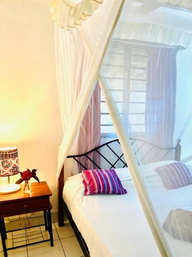 a bedroom with a bunk bed with a window at Cottage Shambala la Africa in Galu