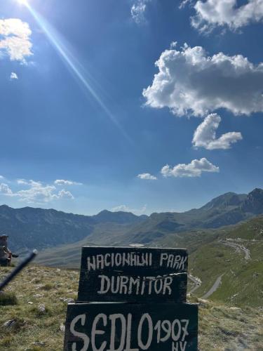 a sign on the top of a mountain with the sun at Cottage Forest Hill in Žabljak