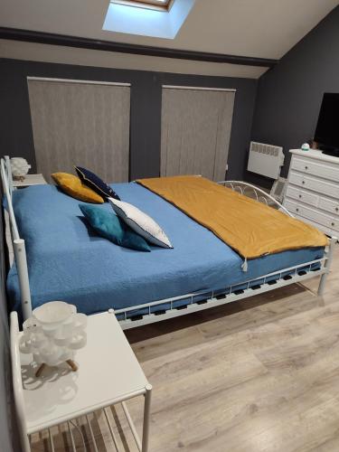 a bedroom with a bed with pillows and a table at Gite Vallée et Semoy in Tournavaux