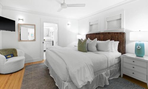 a white bedroom with a large bed and a chair at Just for Fun 2 in Santa Rosa Beach