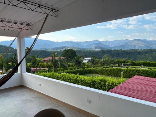 a hammock on a balcony with a view of the mountains at Casa Campestre La Mesita in Palestina