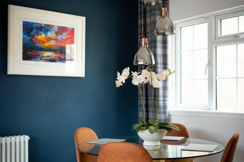 a dining room with a glass table with orange chairs at The Edinburgh Rooftop Terrace in Edinburgh