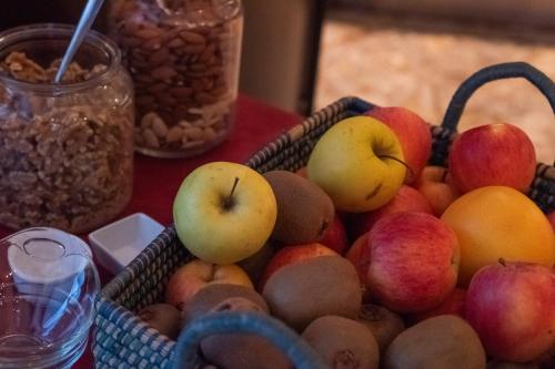a basket of apples and other fruits on a table at Dado Hotel International in Parma