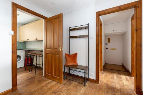 a room with a door and a chair and a kitchen at The Edinburgh Rooftop Terrace in Edinburgh
