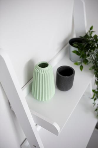 a white shelf with two black vases on it at The Edinburgh Rooftop Terrace in Edinburgh