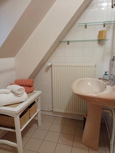 La salle de bains blanche est pourvue d'un lavabo. dans l'établissement La maison de Claire, à Saint-Servant