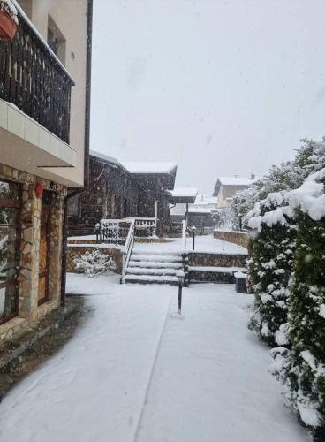 a sidewalk covered in snow next to a building at Andreevite Houses in Sapareva Banya
