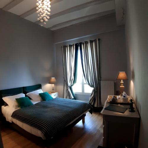 une chambre avec un lit et une fenêtre dans l'établissement L'Arcane Du Bellay, à Montreuil-Bellay