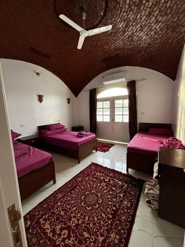 a large room with two beds and a rug at Nile View Guest House in Aswan