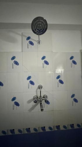 a bathroom with a ceiling fan and blue and white tiles at Neupane's Homestay in Kathmandu