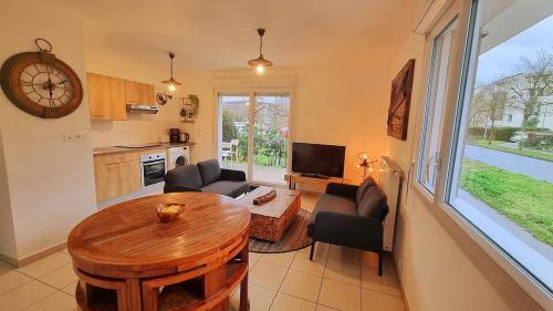 un salon avec une table et une cuisine dans l'établissement Bel appartement à seulement 30 minutes de Paris-la défense, à Cergy