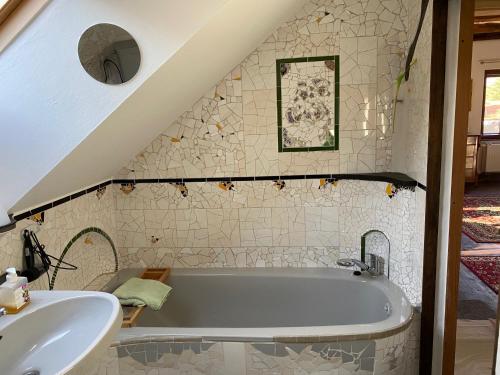 a bathroom with a bath tub and a sink at Charmante Dachgeschosswohnung im historischen Gutshaus in Vetschau