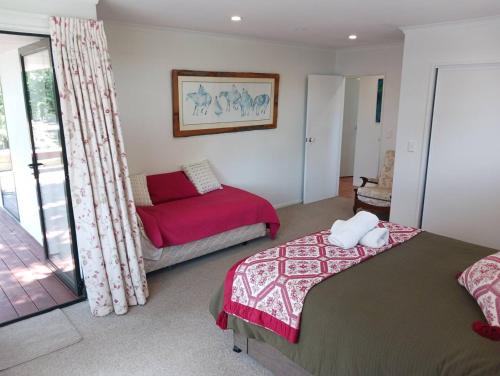 a bedroom with two beds and a couch at Doonside Private Cottage at Grossi Point Reserve in Mapua