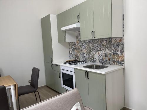 a small kitchen with white cabinets and a sink at Greta family house in Rome