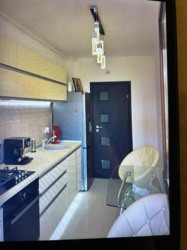 a kitchen with a glass table and chairs in it at Lux studio 46 meters in Colentina