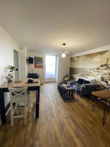 un salon avec un canapé et un lit dans l'établissement perros guirec centre, à Perros-Guirec