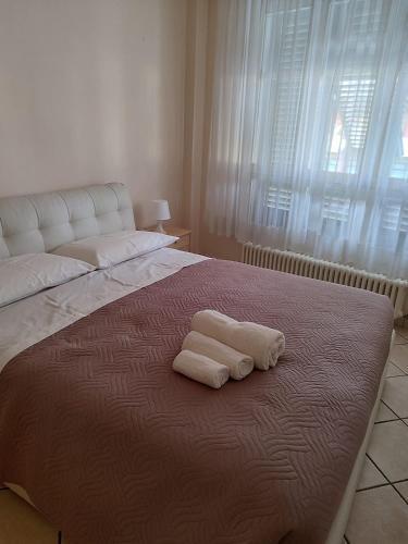 two towels sitting on top of a bed with a window at Diana's home in Empoli
