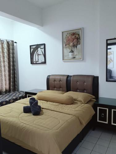 a bed with a teddy bear sitting on top of it at Adira Corus Paradise Seaview Family Suite in Port Dickson