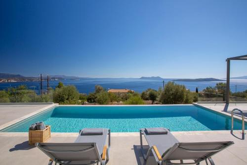 une piscine avec deux chaises longues et une piscine dans l'établissement Brand new High-end villa Astro, à Sývota