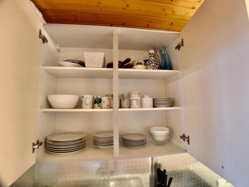 a pantry with plates and dishes on shelves at Ferienwohnung Ferienanlage Pool Sauna Hallenbad Nähe Skipiste Bayer Wald in Hauzenberg