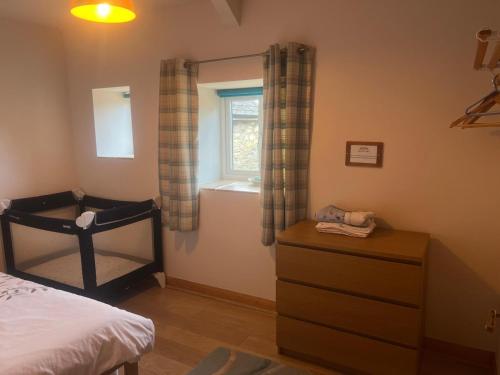 a bedroom with a bed and a window and a dresser at The Milking Parlour in Llandeilo