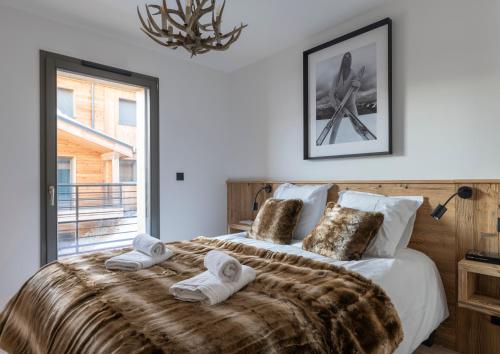 une chambre avec un grand lit avec des serviettes dessus dans l'établissement Appartement Louski, aux Gets