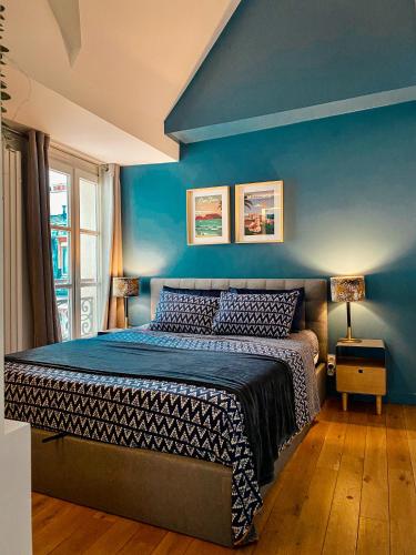 une chambre avec un mur bleu et un lit dans l'établissement Le Marais Apartment Skylight Loft Escape, à Paris