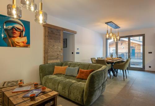un salon avec un canapé vert et une table dans l'établissement Appartement Louski, aux Gets