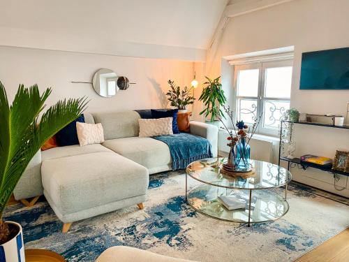 un salon avec un canapé et une table dans l'établissement Le Marais Apartment Skylight Loft Escape, à Paris