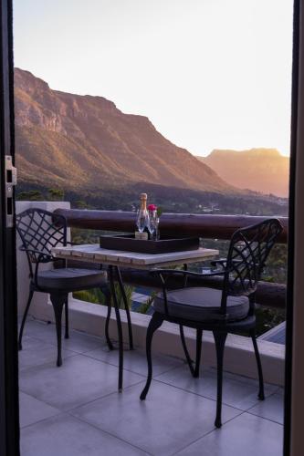 a table and chairs on a balcony with a view at Dreamhouse Guest House in Hout Bay