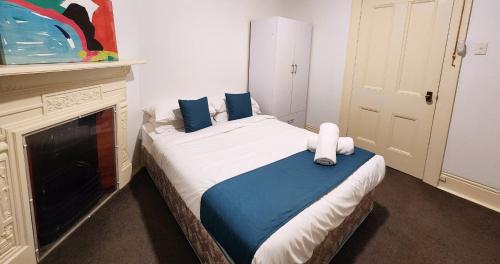a small bedroom with a bed with a fireplace at Discover The Rocks - Historical Terrace House in Sydney