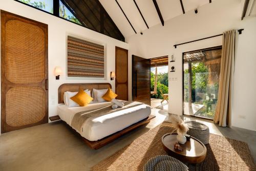 a bedroom with a bed and a large window at Kalani River Villas in General Luna